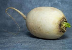 daikon sur fond noir. grosse racine, radis japonais. photo