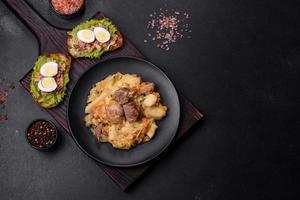 délicieux ragoût de légumes avec boeuf, pommes de terre, carottes et chou dans une assiette noire photo