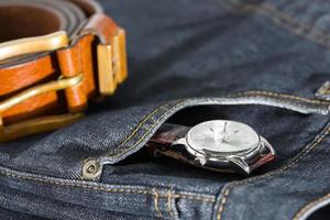 montre-bracelet et ceinture en cuir sur jeans photo