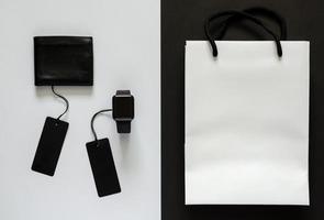 étiquettes de prix noires avec marchandise et sac à provisions blanc sur fond blanc et noir. notion de vendredi noir. photo