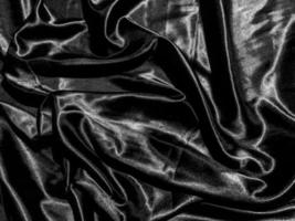 fond de texture satinée noire avec vague liquide ou plis ondulés. conception de papier peint photo
