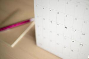page de calendrier gros plan sur fond de table en bois avec stylo et cahier concept de réunion de rendez-vous de planification d'entreprise photo