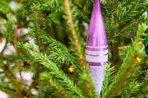 Glaçon en verre violet sur le gros plan de l'arbre de Noël photo