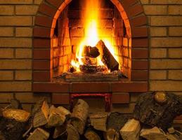 tas de bois de chauffage et langues de feu dans la cheminée photo