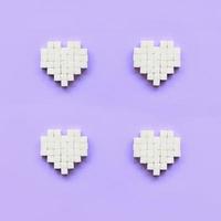 quelques coeurs faits de cubes de sucre se trouvent sur un fond violet pastel tendance photo