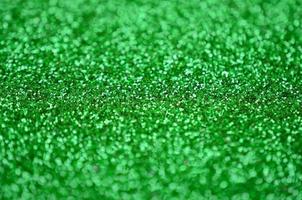 une énorme quantité de paillettes décoratives vertes. image de fond avec des lumières bokeh brillantes à partir de petits éléments photo