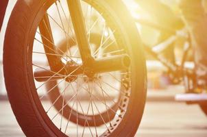 une roue de vélo bmx sur fond de rue floue avec des cyclistes. concept de sports extrêmes photo