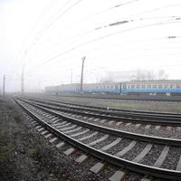 le train de banlieue ukrainien se précipite le long de la voie ferrée par un matin brumeux. photo fisheye avec distorsion accrue