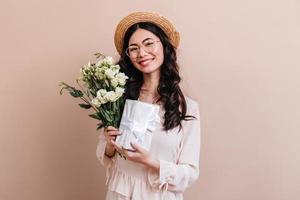 tourné en studio d'une fille japonaise avec des fleurs blanches. charmant modèle asiatique tenant un bouquet d'eustoma et g photo
