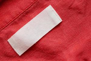 Étiquette de vêtements vierges sur fond de texture de tissu de chemise en lin photo