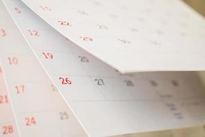 feuille de retournement de page de calendrier gros plan sur fond de table de bureau concept de réunion de rendez-vous de planification d'horaire d'entreprise photo