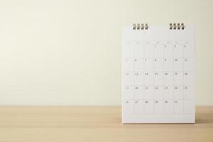 page de calendrier gros plan sur une table en bois avec fond de mur blanc concept de réunion de rendez-vous de planification d'entreprise photo