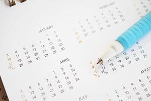 stylo en gros plan sur la page du calendrier pour marquer le concept de planification de la date photo