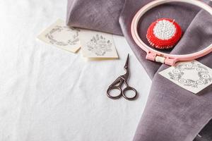 ensemble de broderie. toile de lin, motifs de broderie, cercle à broder et aiguilles. photo