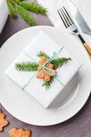 cadre de table de fête de noël, assiette avec cadeau décoré de brins d'épinette et de pain d'épice photo