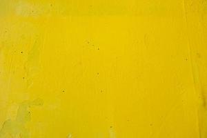 vieux mur peint avec de la peinture jaune avec des fissures et des bulles photo