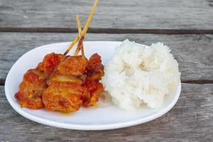 le porc grillé avec du riz gluant dans une assiette blanche est un aliment que les thaïlandais préfèrent manger, il y a des ventes générales le long du chemin. photo