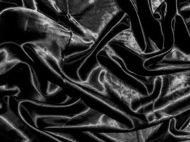 tissu noir ou fond d'exture de tissu avec une vague liquide ou des plis ondulés. conception de papier peint photo