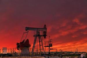 plate-forme de forage pétrolier et cric de pompe sur fond de coucher de soleil. photo