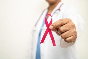 cancer du sein, femme médecin asiatique avec ruban rose, symbole de la journée mondiale du cancer du sein. photo