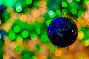 boule bleue suspendue à décorer pour les vacances de noël avec un bokeh coloré de la lumière et d'autres boules. photo