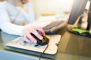 main sur la souris d'une fille au bureau photo