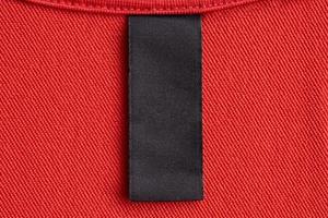 étiquette de vêtements de soin de blanchisserie noir blanc sur fond de texture de tissu rouge photo