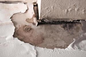 Toit de plafond endommagé par l'eau, vieux plafond de plaques de plâtre blanc pourri dans la maison endommagé par des fuites d'eau provenant de gouttes de pluie photo