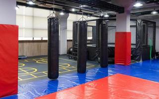 une cage de kickboxing octogonale avec des sacs de boxe dans le complexe sportif photo