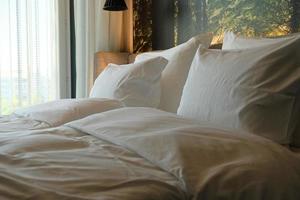 un fragment d'une chambre à coucher avec un design intérieur confortable et moderne d'une maison ou d'un hôtel. oreiller et couverture moelleux, mobilier élégant et confortable. photo
