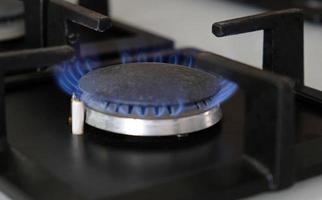 gros plan des flammes bleues du feu sur un brûleur à gaz dans la cuisine pour la cuisson. flamme de gaz dans une chaudière à gaz photo