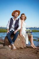 couple heureux sur la plage avec un bouquet de fleurs photo