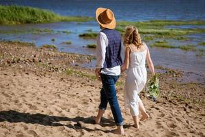 jeune couple marche le long du rivage photo