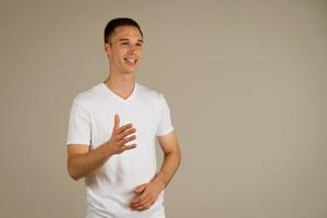 homme dans un t-shirt blanc gestes sur le fond photo