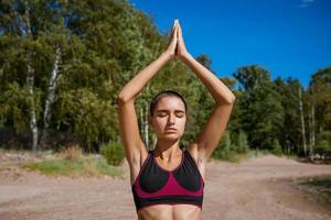 jeune femme mince faisant du yoga à l'extérieur sur la baie de rivage sablonneux par une journée ensoleillée. unité photo