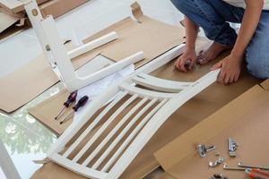 homme assemblant des meubles de chaise blanche à la maison photo