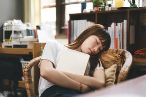 une étudiante adolescente asiatique tient une tablette numérique et fait une sieste assise sur une chaise reste à la maison. photo