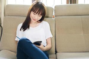 femme adolescente asiatique lisant un livre pour apprendre et étudier à la maison. photo