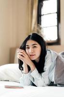 portrait jeune adulte jolie femme asiatique après le réveil le matin avec la lumière du soleil photo