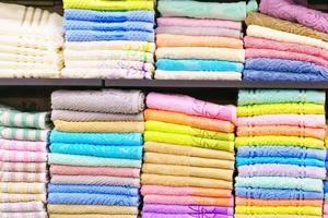 serviettes multicolores sur une étagère sur le marché, vente de serviettes en coton, coton de couleur pile photo