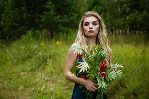 portrait d'une belle femme avec un bouquet de rowan photo