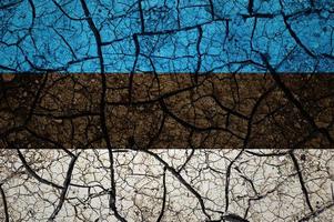 motif de sol sec sur le drapeau de l'estonie. pays avec concept de sécheresse. problème d'eau. terre sèche fissurée. photo