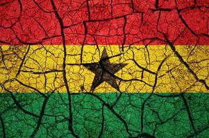 motif de sol sec sur le drapeau du ghana. pays avec concept de sécheresse. problème d'eau. terre sèche fissurée. photo