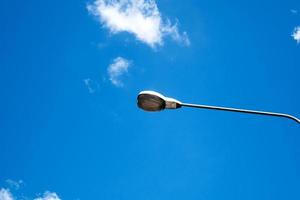 lampadaire électrique moderne avec ciel bleu et nuage en arrière-plan. le lampadaire en acier ou la lanterne sur poteau pendant la journée sont conceptualisés dans l'industrie, la technologie et l'urbanisation photo