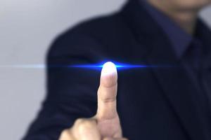 un homme d'affaires doigt touchant la lumière bleue de la technologie, un homme d'affaires intelligent cliquant sur un effet de lumière bleue de l'écran virtuel, utilisé dans la conception commerciale et technologique photo