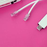 un routeur Internet, un adaptateur wi-fi usb portable et des prises de câble Internet se trouvent sur un fond rose vif. éléments nécessaires pour Internet photo