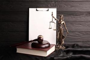 dame justice ou justitia la déesse romaine de la justice. statue sur livre brun avec marteau de juge sur fond de papier vierge avec espace pour copie. concept de procès judiciaire, de procédure judiciaire et de travail des avocats photo