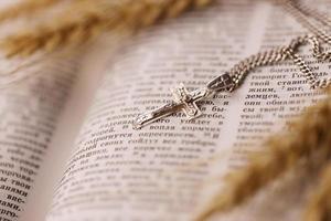 collier en argent avec croix crucifix sur le livre chrétien de la sainte bible sur une table en bois noire. demander des bénédictions à Dieu avec le pouvoir de la sainteté photo