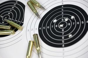 de nombreuses balles sur des cibles de tir sur un tableau blanc dans un polygone de champ de tir. formation à la visée et au tir photo