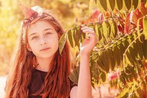 portrait d'une adolescente dans un chapeau de sorcière orange pour halloween. portrait d'automne d'une fille d'âge scolaire. photo